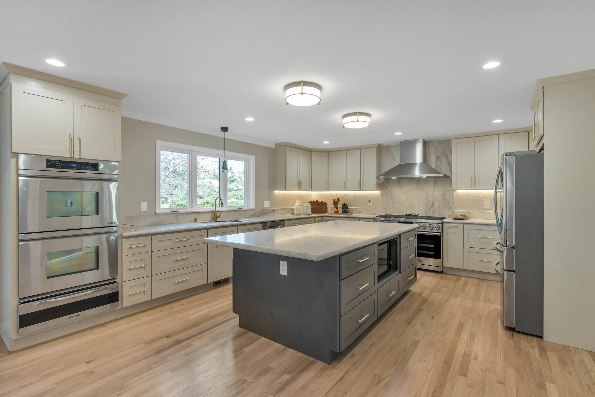 Completed Danville kitchen remodel with soft cabinetry, a two-tone island, stainless appliances, and natural light by Inspired Builders
